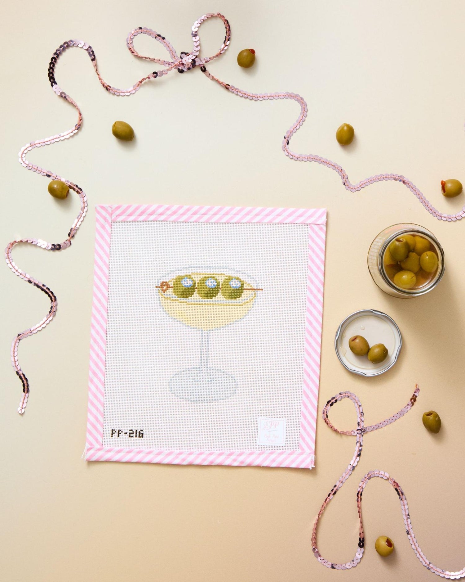 Martini needlepoint canvas with olive details, pink trim, sequins, and cocktail styling for a quick weekend project