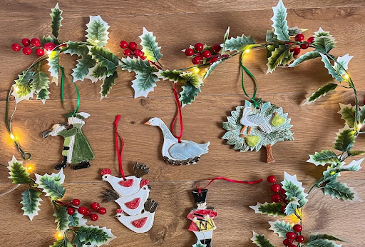 Festive holiday garland with lights and ornaments, styled as inspiration for Christmas needlepoint projects and handmade holiday décor.