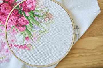 Hand-painted needlepoint canvas mounted on a round hoop, showing crisp stitch zones and color clarity for easy stitching.