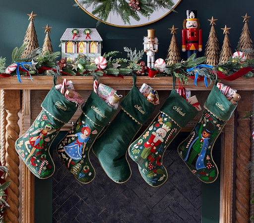 Personalized needlepoint stockings hanging from a fireplace mantel with Christmas decor, ideal holiday needlepoint projects